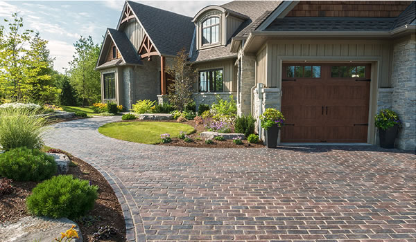 Unilock brick pavers in driveway with beautiful home and landscaping